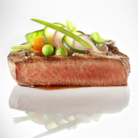 photo culinaire design petits légumes sur pavé de bœuf saignant fond blanc brillant